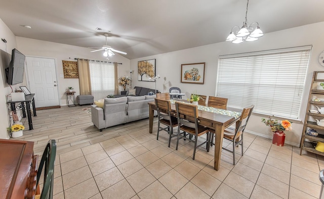 dining room with lofted ceiling, baseboards, visible vents, and ceiling fan with notable chandelier