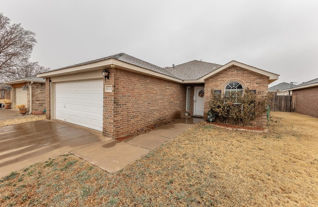 single story home with brick siding, a shingled roof, concrete driveway, fence, and a garage