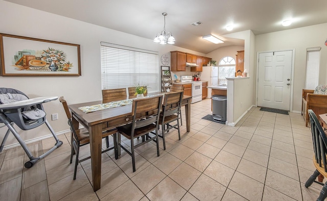 dining area featuring light tile patterned floors, baseboards, visible vents, lofted ceiling, and a chandelier