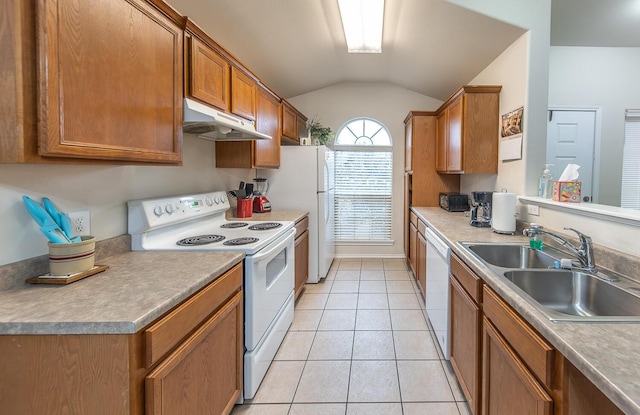 kitchen featuring light tile patterned floors, under cabinet range hood, white appliances, a sink, and vaulted ceiling