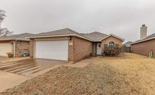 single story home featuring an attached garage, brick siding, a shingled roof, concrete driveway, and a front lawn