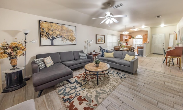 living room featuring a ceiling fan, wood finish floors, visible vents, and vaulted ceiling