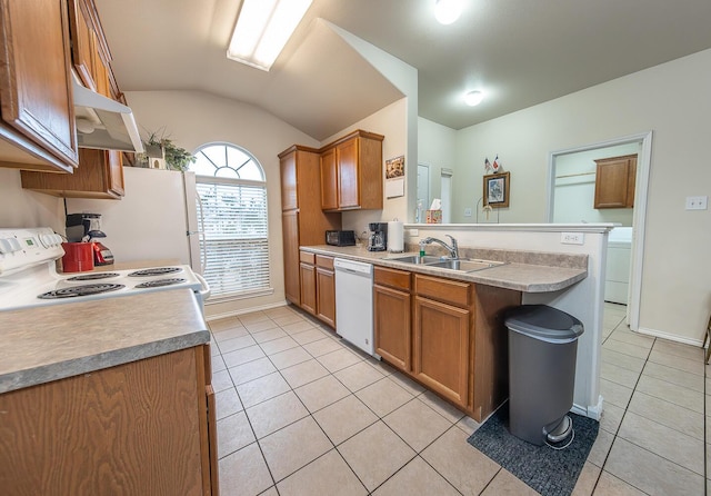 kitchen with white appliances, light tile patterned floors, brown cabinets, and a sink