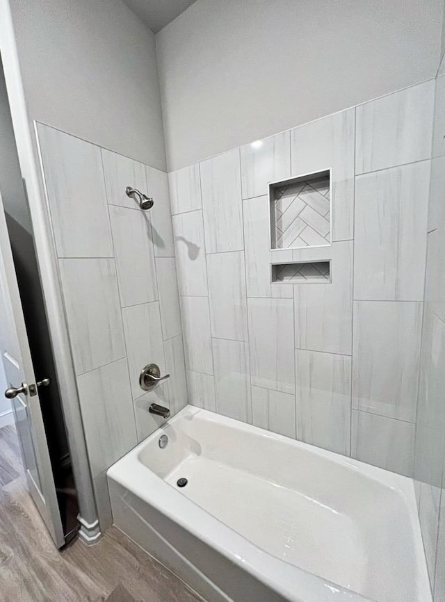 bathroom with wood-type flooring and tiled shower / bath combo