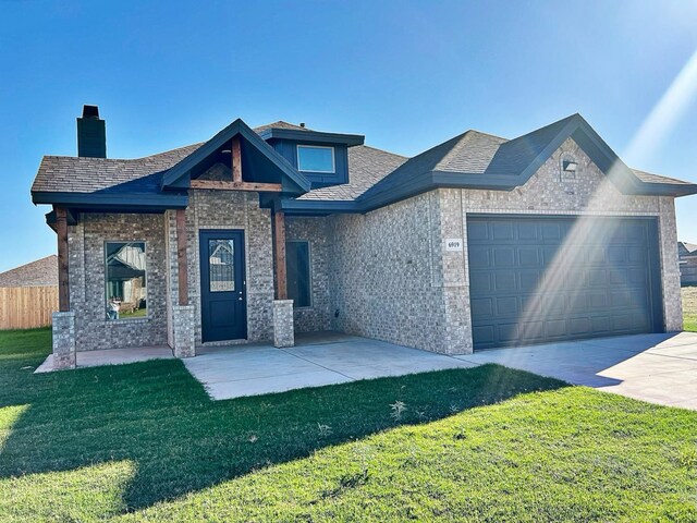 view of front of house featuring a garage and a front lawn