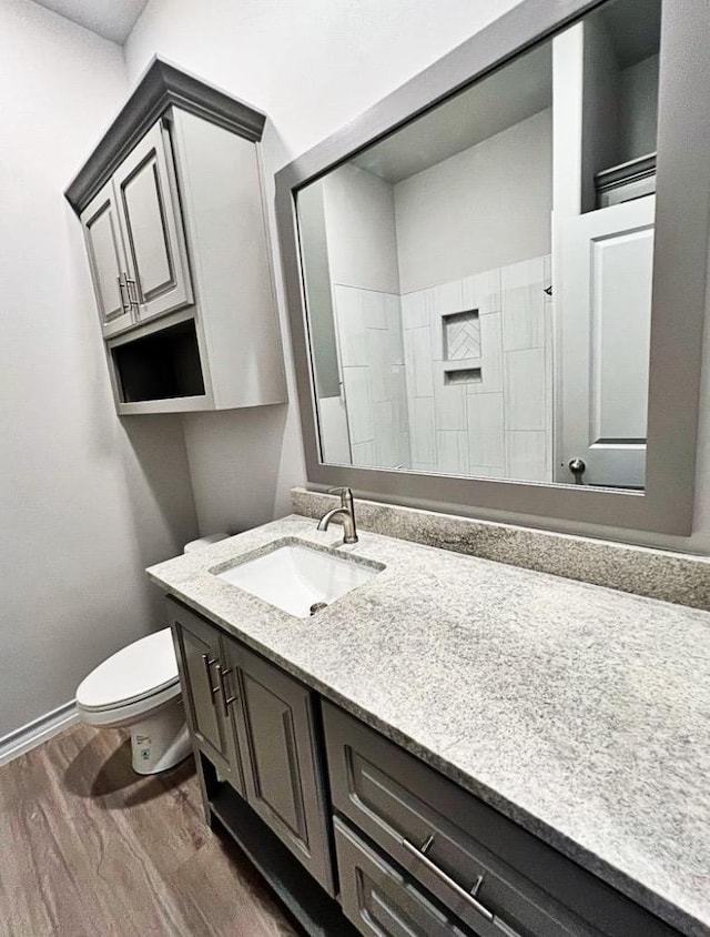 bathroom featuring wood-type flooring, vanity, and toilet