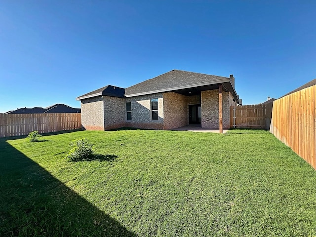 rear view of property featuring a lawn and a patio