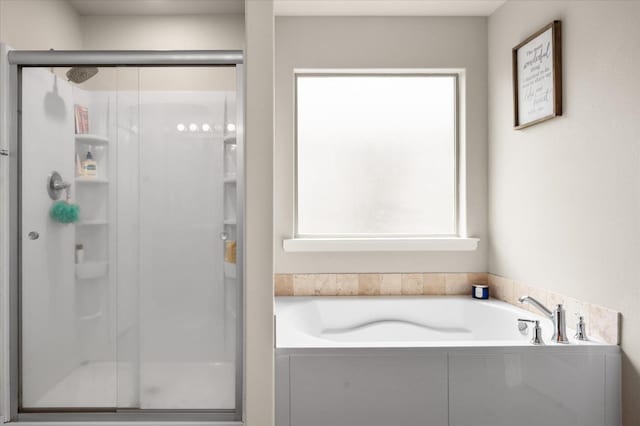 bathroom featuring a wealth of natural light and plus walk in shower