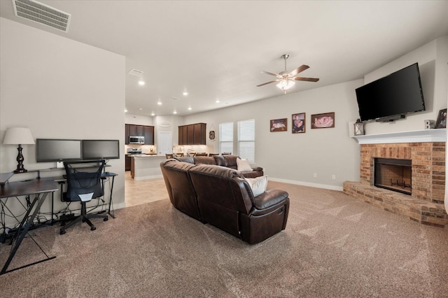 carpeted living room featuring ceiling fan and a brick fireplace