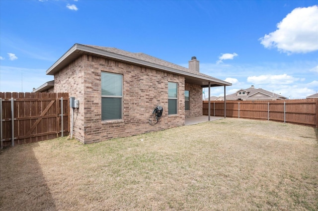 back of house with a lawn and a patio