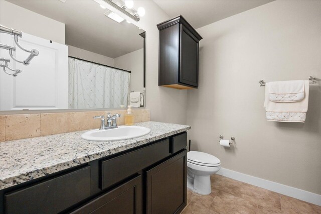 bathroom featuring vanity, decorative backsplash, tile patterned floors, and toilet