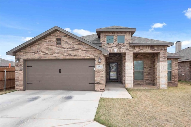 view of front of property featuring a garage and a front lawn