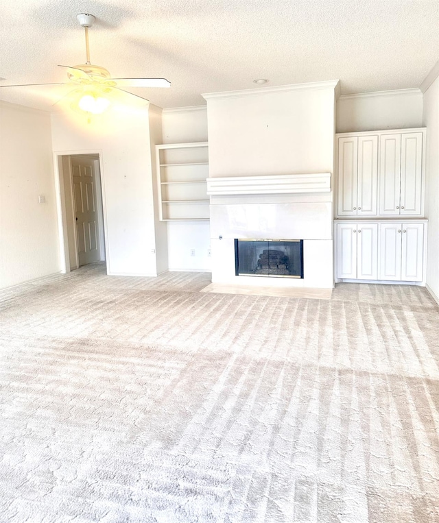 unfurnished living room featuring light carpet, ceiling fan, crown molding, and a textured ceiling