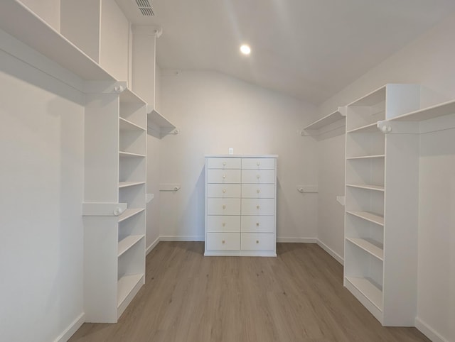 spacious closet featuring vaulted ceiling and light hardwood / wood-style floors