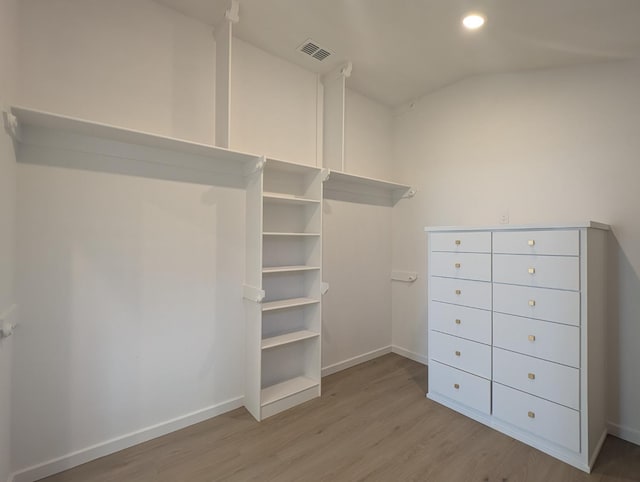 spacious closet featuring lofted ceiling and light wood-type flooring