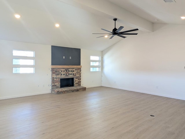 unfurnished living room with lofted ceiling with beams, ceiling fan, a fireplace, and light hardwood / wood-style floors