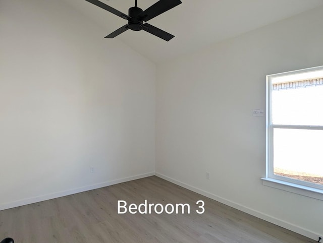 empty room featuring ceiling fan, plenty of natural light, light hardwood / wood-style flooring, and lofted ceiling