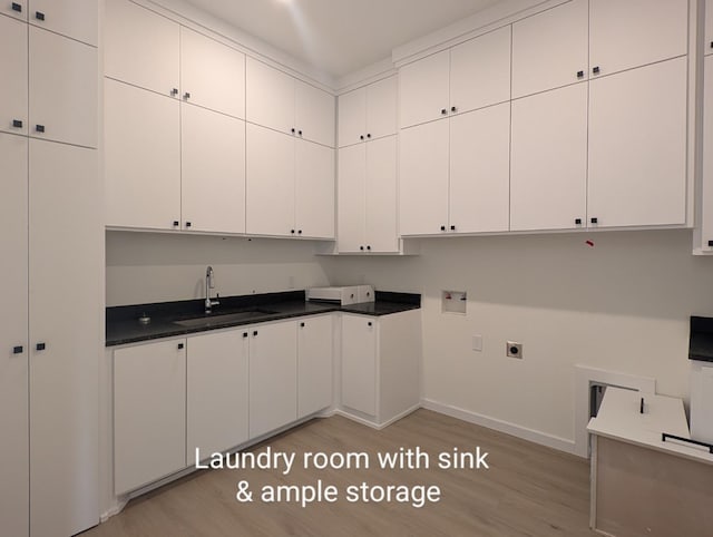 kitchen featuring white cabinetry, sink, and light hardwood / wood-style flooring