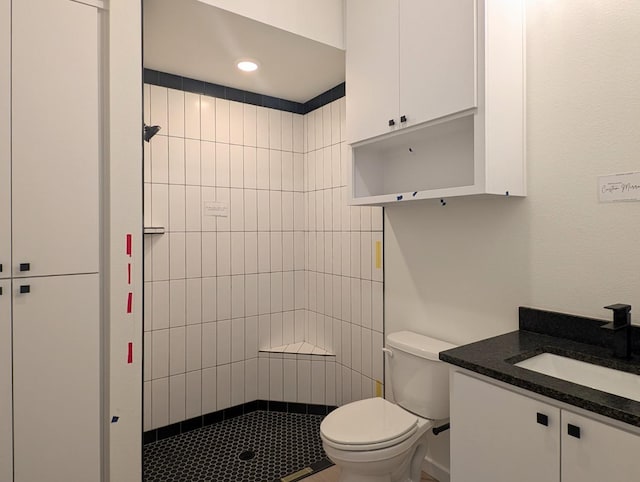 bathroom featuring vanity, toilet, and tiled shower