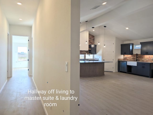 kitchen featuring sink, hanging light fixtures, dishwasher, hardwood / wood-style flooring, and backsplash