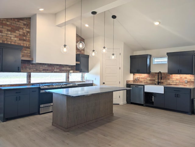 kitchen with sink, hanging light fixtures, a center island, stainless steel appliances, and light wood-type flooring