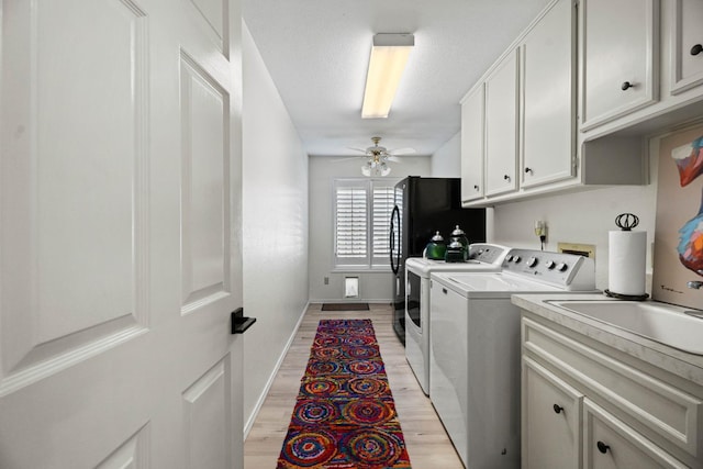 laundry area with ceiling fan, cabinets, separate washer and dryer, and light hardwood / wood-style floors