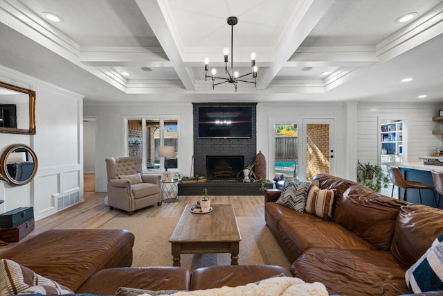 living room with coffered ceiling, beam ceiling, a brick fireplace, and light hardwood / wood-style flooring