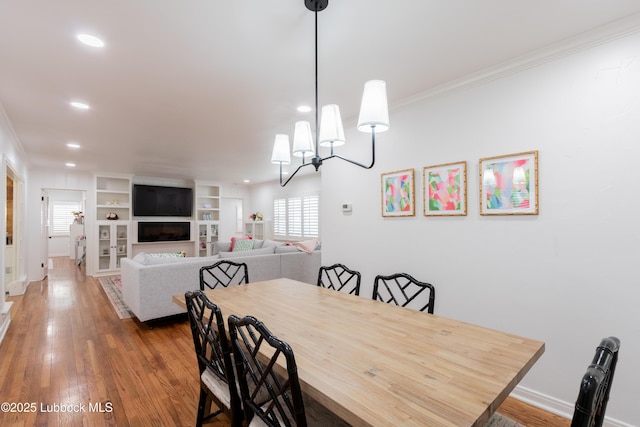 3014 25th St, Lubbock, TX 79410 - dining space with crown molding, wood finished floors, recessed lighting, a chandelier, and baseboards