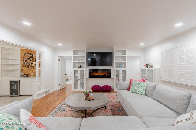 3014 25th St, Lubbock, TX 79410 - living area with wine cooler, light wood-style flooring, crown molding, a large fireplace, and recessed lighting