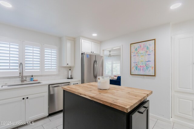 3014 25th St, Lubbock, TX 79410 - kitchen featuring stainless steel appliances, butcher block countertops, a sink, light tile patterned floors, and recessed lighting