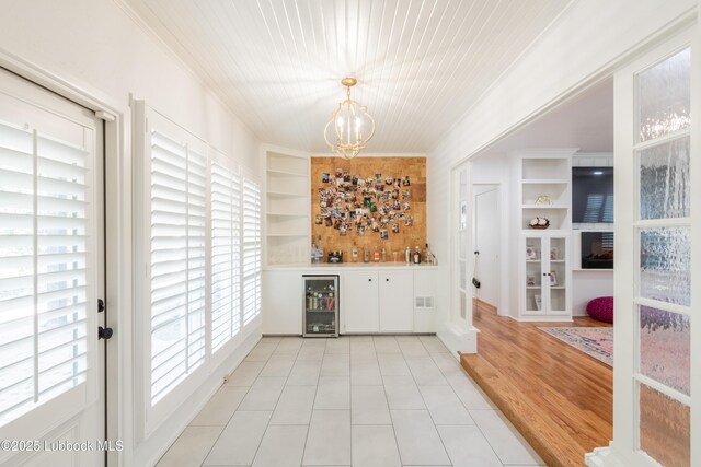 3014 25th St, Lubbock, TX 79410 - indoor dry bar featuring built in shelves, a chandelier, pendant lighting, and light tile patterned floors