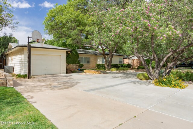 3014 25th St, Lubbock, TX 79410 - view of front of property with concrete driveway, an attached garage, and cooling unit
