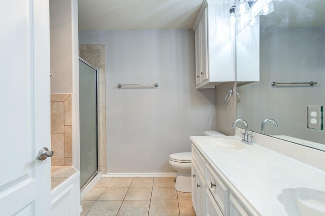 bathroom featuring a shower with door, vanity, tile patterned floors, and toilet