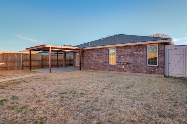 back of property featuring a patio, a shed, and a lawn