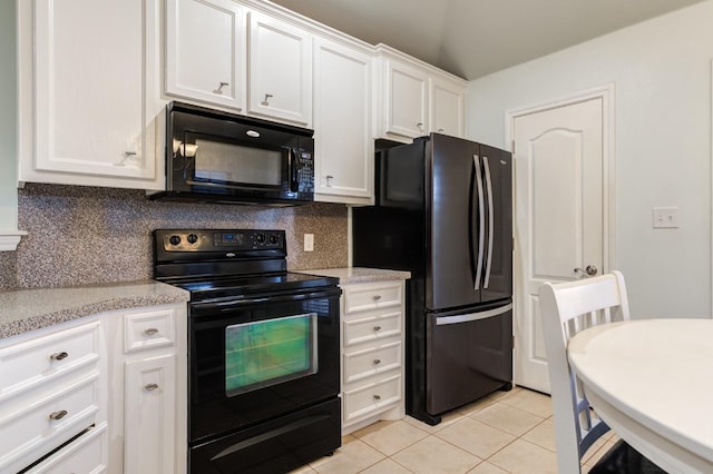 kitchen featuring white cabinetry, decorative backsplash, light tile patterned floors, black appliances, and light stone countertops