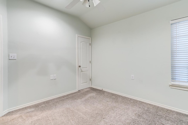 empty room featuring light colored carpet, ceiling fan, and vaulted ceiling