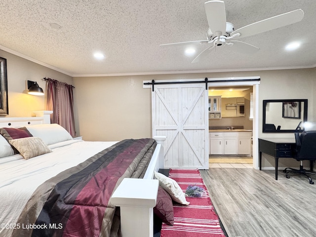 5226 92nd St, Lubbock, TX 79424 - bedroom featuring light wood-style flooring, a barn door, crown molding, recessed lighting, and a textured ceiling
