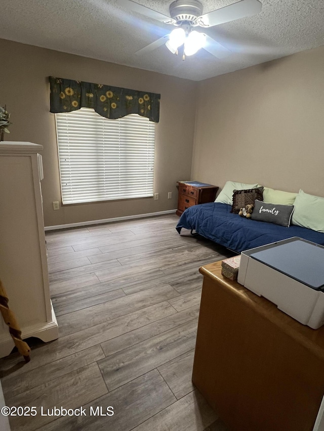 5226 92nd St, Lubbock, TX 79424 - bedroom featuring a textured ceiling, wood finished floors, baseboards, and a ceiling fan