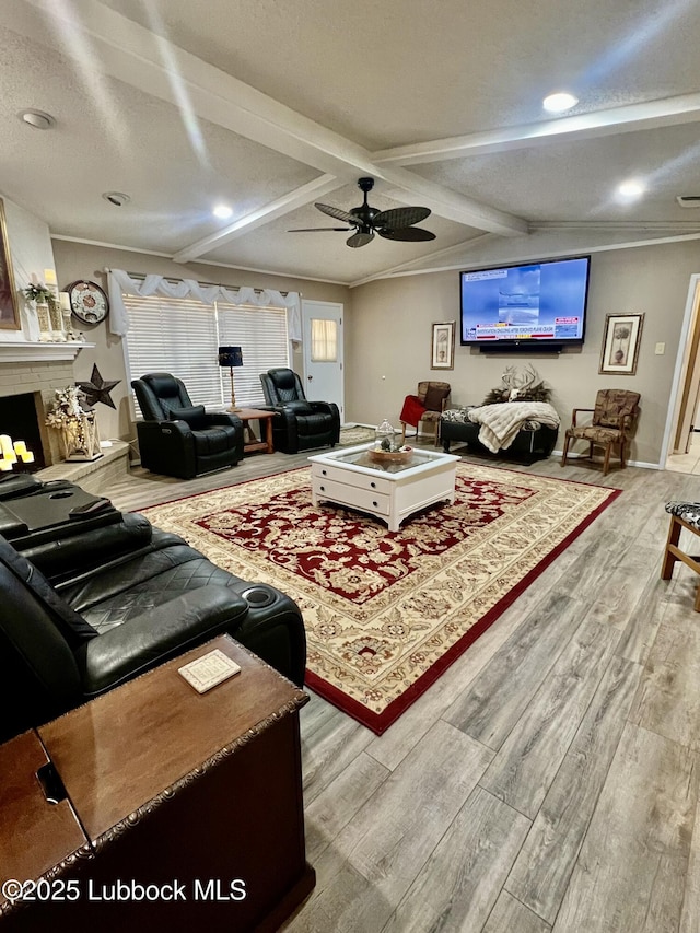 5226 92nd St, Lubbock, TX 79424 - living room with wood finished floors, a ceiling fan, a fireplace with raised hearth, recessed lighting, and beamed ceiling
