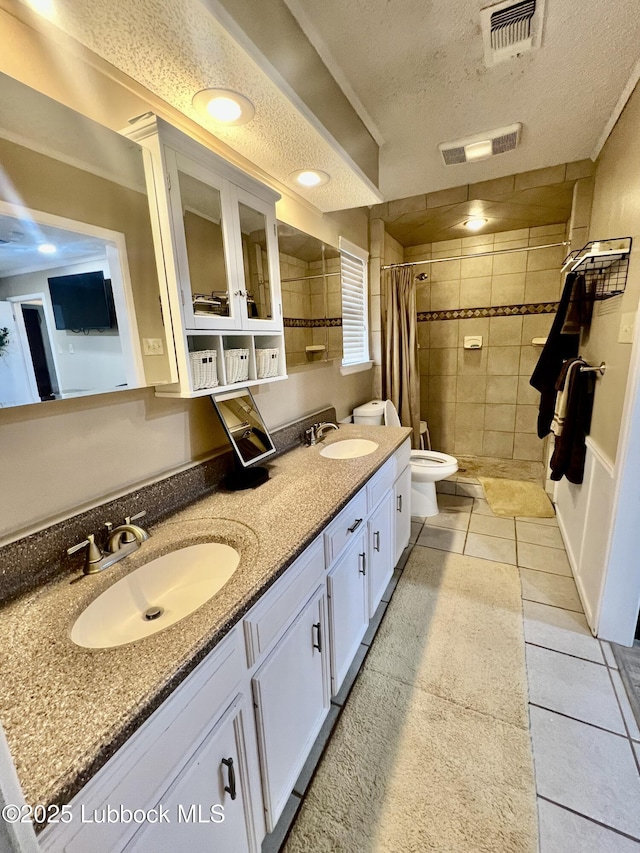 5226 92nd St, Lubbock, TX 79424 - full bath featuring a textured ceiling, tiled shower, toilet, tile patterned floors, and double vanity