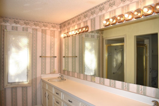 bathroom with vanity, a textured ceiling, and walk in shower