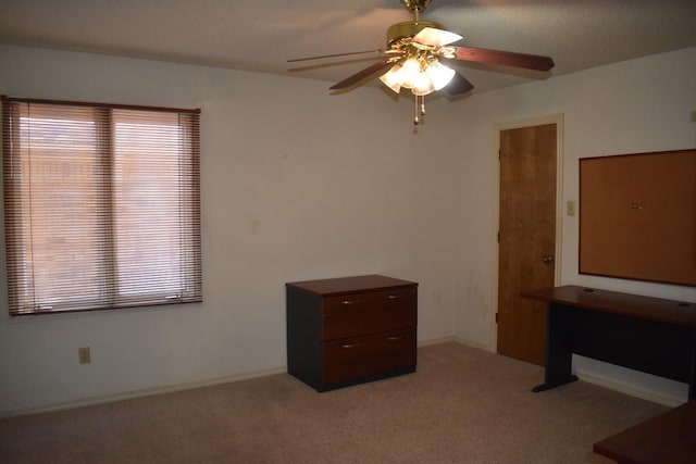 unfurnished bedroom featuring ceiling fan, multiple windows, and light carpet