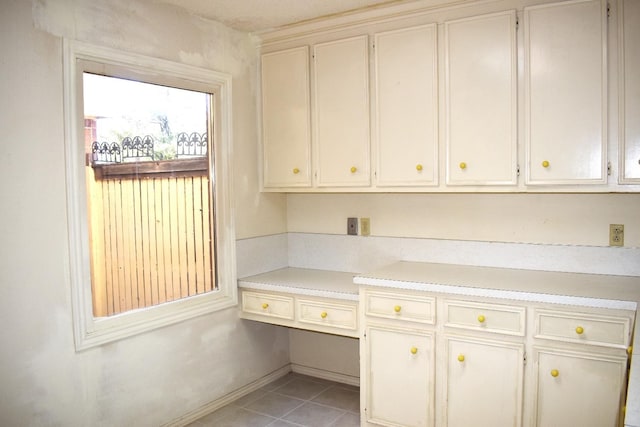 interior space featuring built in desk and light tile patterned floors