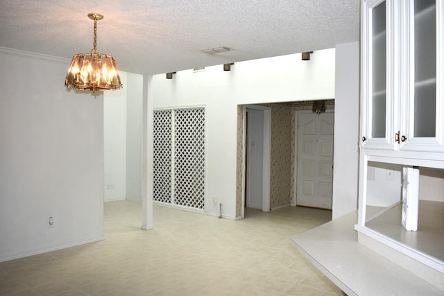 unfurnished dining area featuring an inviting chandelier and a textured ceiling