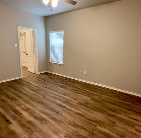 empty room featuring ceiling fan and dark hardwood / wood-style flooring