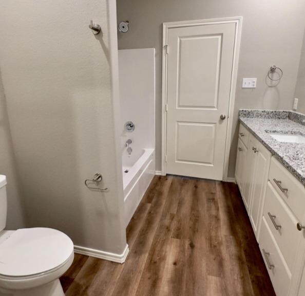 full bathroom with toilet, shower / tub combination, vanity, and wood-type flooring