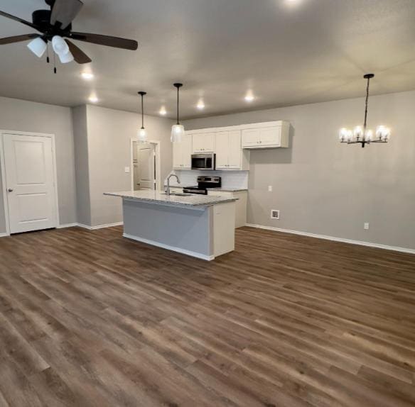 kitchen with white cabinetry, stainless steel appliances, a center island with sink, and dark hardwood / wood-style floors