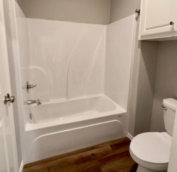 bathroom featuring toilet, bathtub / shower combination, and wood-type flooring