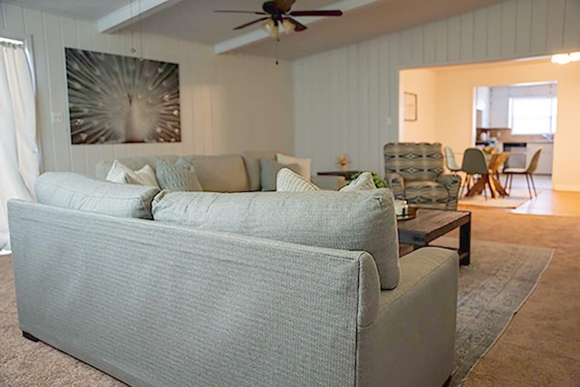 carpeted living room with lofted ceiling with beams and ceiling fan