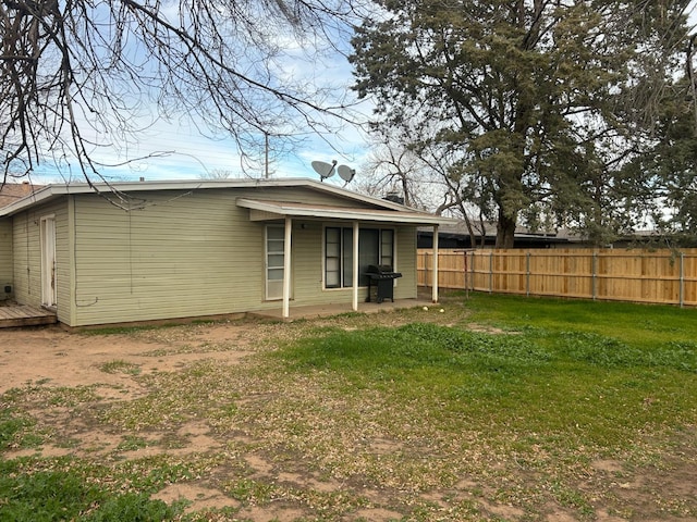 rear view of property with a yard